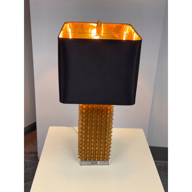 Design Plus Gallery presents the Spike Table Lamp from J. Alexander Lighting. The rectangular gold-tone column is covered...