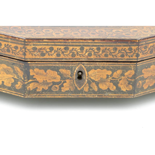 A painted or penwork games box decorated with assorted playing cards on the lid; English, circa 1840-1850. An eight-sided...