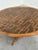 A striking vintage round coffee table combining warm-toned wood with an exceptionally decorative etched brass top. The...