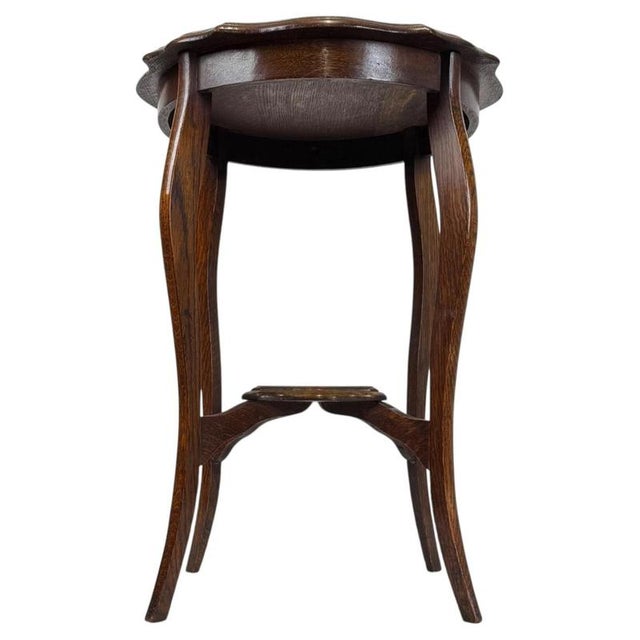 A charming early 20th-century English side table, finely crafted from oak and distinguished by its graceful cabriole legs,...