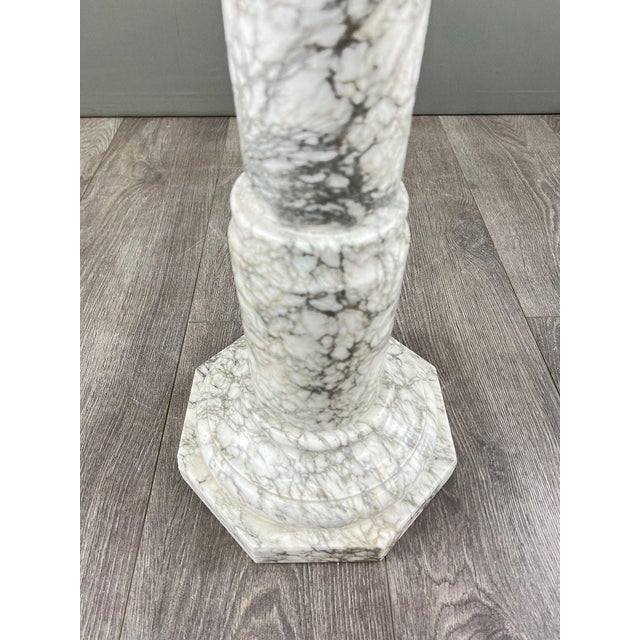 Elegant column in white marble veined with gray, featuring an octagonal base and top. The shaft is finely turned in a...