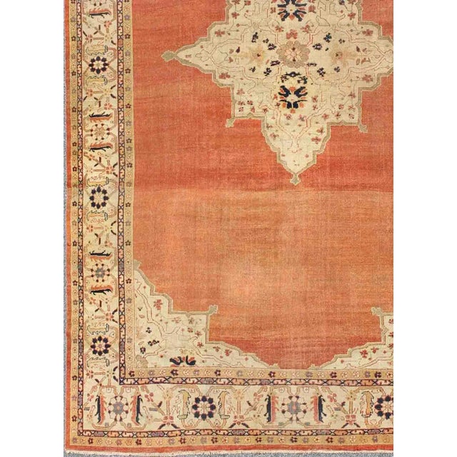 Large Antique Ziegler Sultanabad rug with central medallion in soft orange, ivory and pops of navy blue. Keivan Woven Arts...