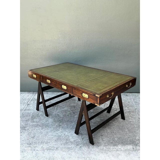 This campaign desk embodies the utilitarian elegance long associated with military-inspired furniture design, its...