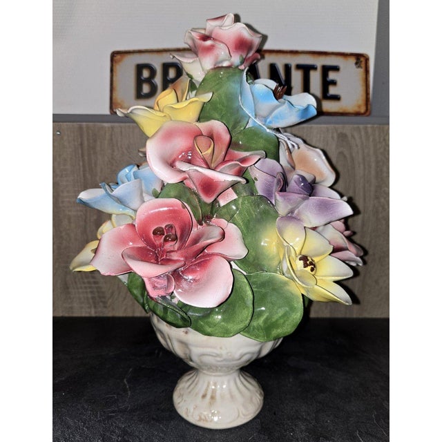 Capodimonte: A floral composition in slipware, featuring polychrome flowers in relief, with delicate shapes and soft,...