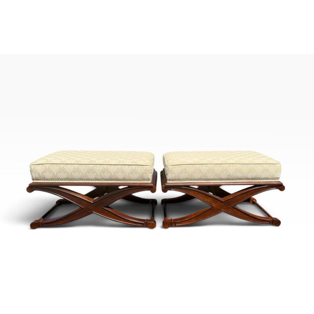 Beautiful pair of vintage upholstered ottomans with distinctive X-form mahogany-finished wood bases. The upholstered tops...