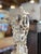 A monumental and exceptionally ornate silvered metal ewer with coordinating underplate, richly modeled throughout with...