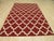 This 8 x 10 feet wool rug features a flat weave construction in a primary color palette of coral, salmon, and pink....