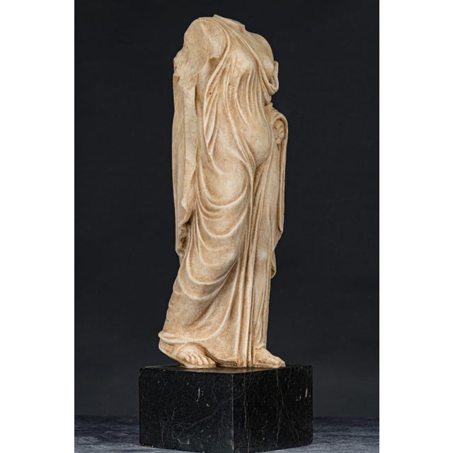 Ancient statue of a vestal, in Carrara marble with a black marble base, 19th century, in good intact condition.