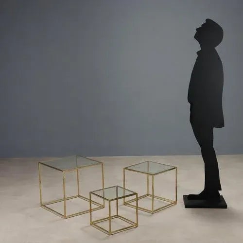 Three vintage coffee tables with brass frames and square glass tops. This piece is attributed to the mentioned...