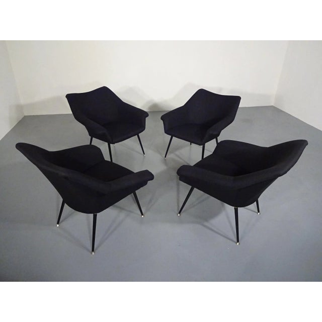 Italian club chair from the 1960s. Restored and reupholstered. Black lacquered metal legs with leveling feet. Four...