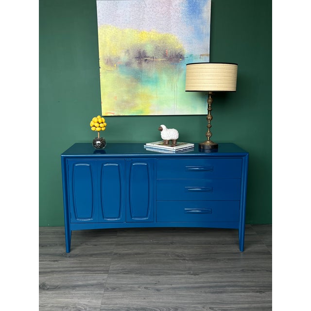 This is a solid built Mid-Century walnut dresser featuring three drawers and double doors. This dresser is newly...