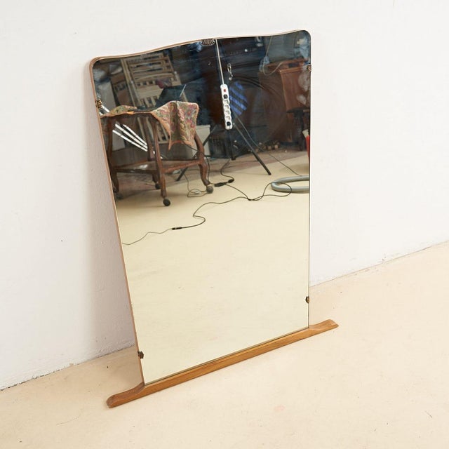 This elegant vintage mirror is a unique piece of 20th-century design. Featuring a sinuous shape and a glossy finish, the...