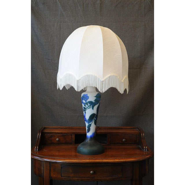 1950s Lamp. An eccentric 1950s-style lamp, featuring a large white shade with fine fringes, a slightly curved linear body...