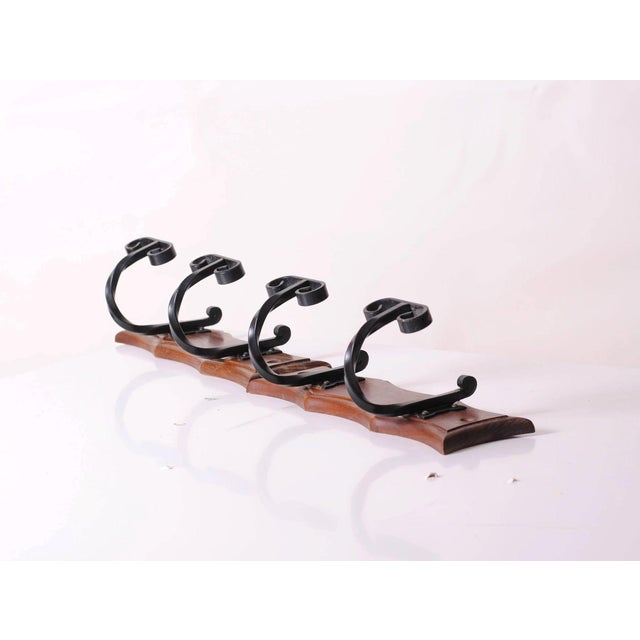 This set of two wall-mounted coat racks combines the warmth of wood with the sturdiness of wrought iron, embodying an...