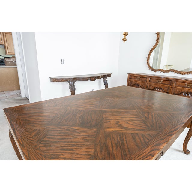 A substantial custom-built dining table crafted in the French Provincial style, featuring a beautifully executed parquet...