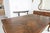 A substantial custom-built dining table crafted in the French Provincial style, featuring a beautifully executed parquet...