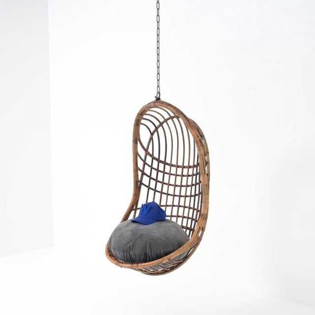 This wonderful rattan egg chair is suspended from the ceiling by chain. We date it back to the 1970s. The chair features...