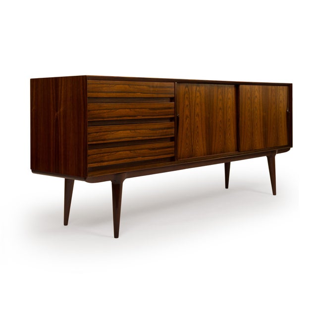 A true piece of mid-century Scandinavian history, this Model 18 credenza was designed by Gunni Omann for the family-owned...