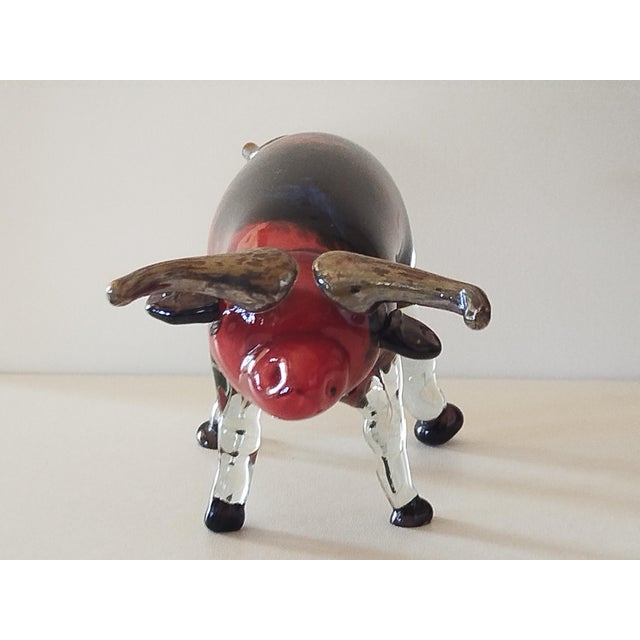 Sculpture of a bull in blown glass and silver nitrate. The bull's body is made of solid glass paste, in deep, dark tones...