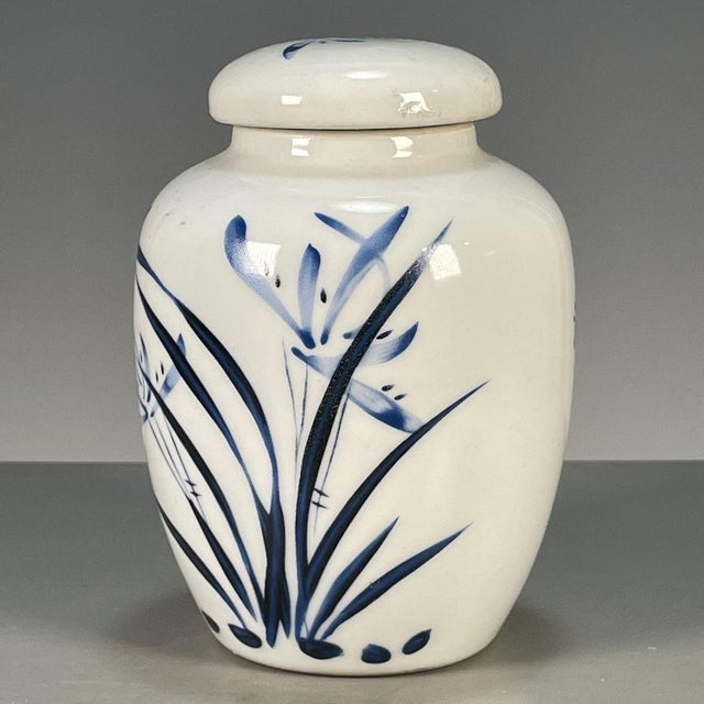 This is an elegant vintage porcelain tea jar, decorated in the classic blue and white palette with subtle gilded accents....