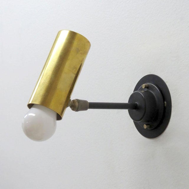 Elegant articulate wall lights, in brass and black enameled metal, swivel joint at the cylinder, complementary detachable...