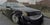 Camp Washington Caddy by Brad Davis | Oil on wood panel Black car with damage parked on street For Sale