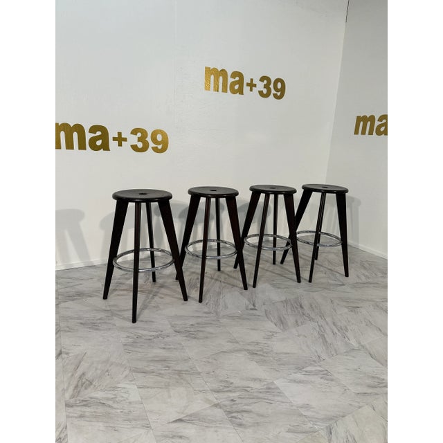 The Set of 4 Tabouret Haut Jean Prouvé Bar Stools by Vitra in Dark Oak showcases iconic mid-century design with a...