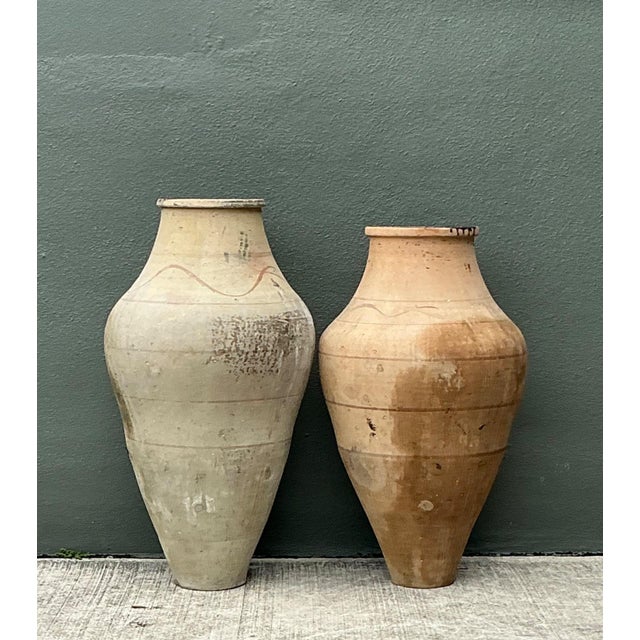 This pair of monumental Turkish terracotta vessels exudes a timeless, architectural presence, perfect for adding a sense...