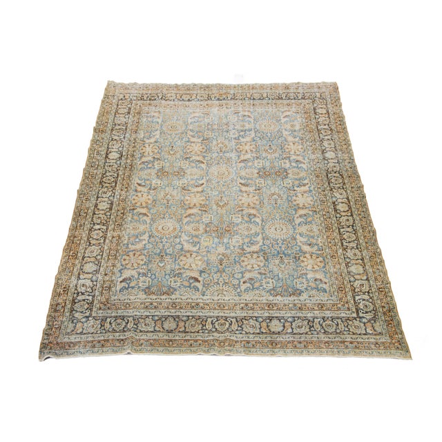 This Persian Tabriz wool rug, handcrafted, showcases a traditional floral pattern. The contrast between the blue backdrop...