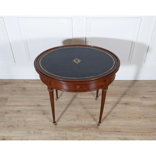 Refined and unusually versatile Louis XVI–style oval table in mahogany and mahogany veneer, dating from the 19th century....