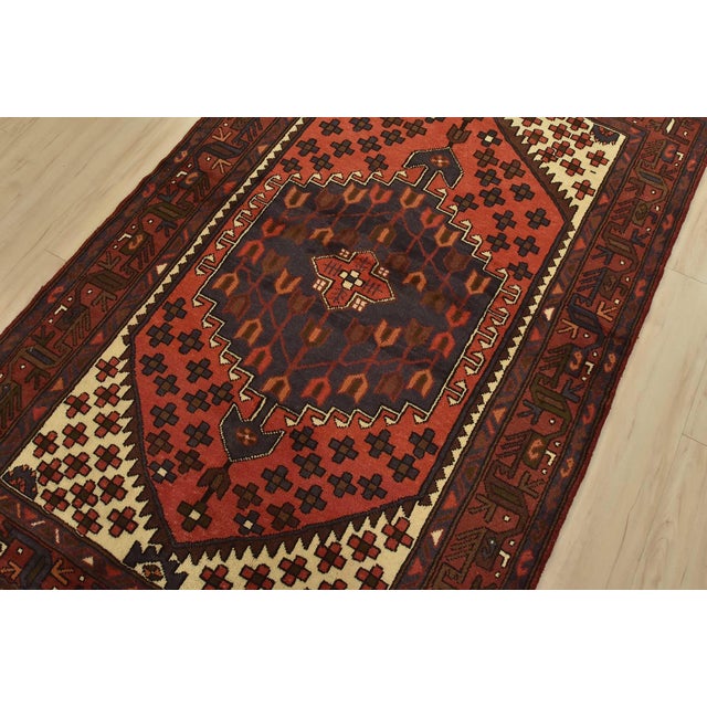 An authentic vintage tribal Hamedan rug hand-knotted with fine wool and natural dyes. This nomadic rug features a central...
