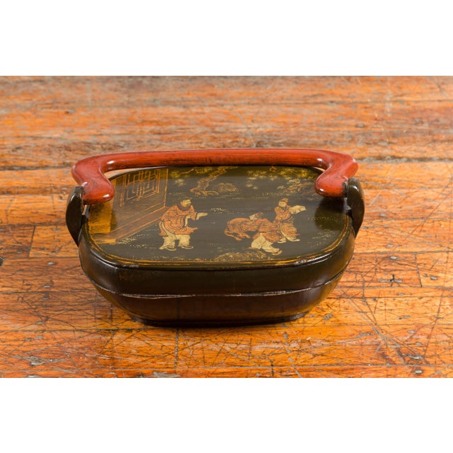 A Chinese vintage black lacquer lidded box from the mid 20th century, with hand-painted Chinoiserie décor. Created in...