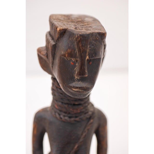 A striking pair of carved female figures from Tanzania, dating to the 1940s–1950s. Finely sculpted with delicate facial...