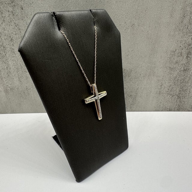 This elegant diamond cross necklace in 10kt yellow gold features 0.12 carats total weight of natural HI I1 round single...