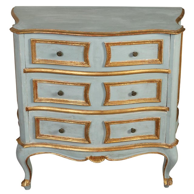 Charming small-scale French-style painted commode featuring a softly distressed pale blue finish with warm gilt detailing...