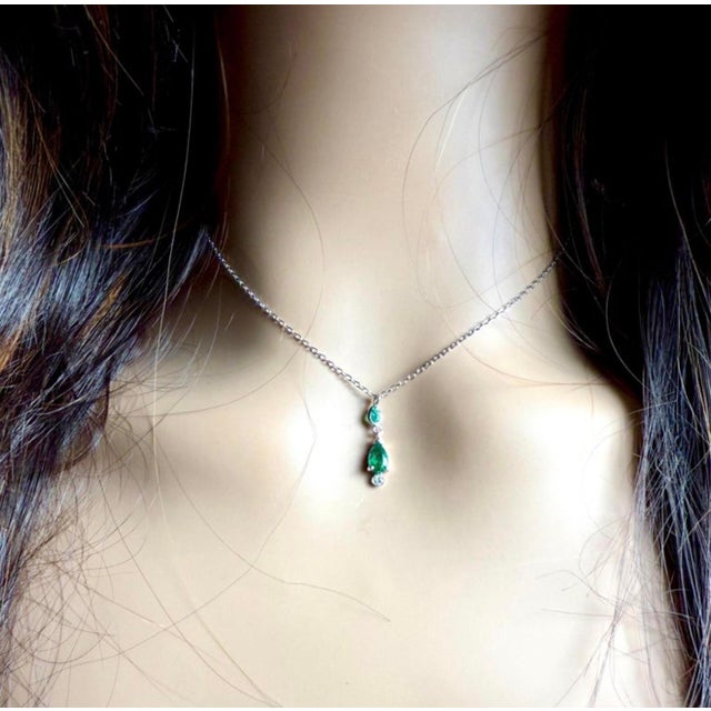 Elevate your everyday elegance with this refined 14K white gold necklace featuring two matched pear-shaped emeralds,...