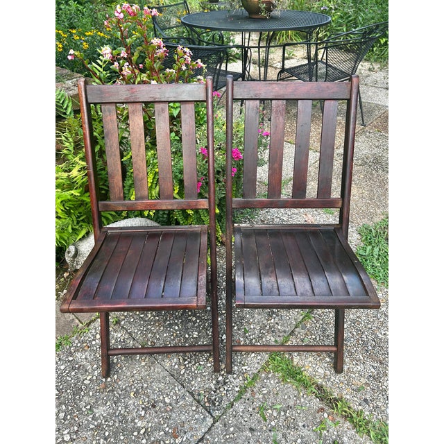 This pair of early 20th-century American Arts & Crafts folding chairs, was crafted from solid oak with a rich, naturally...