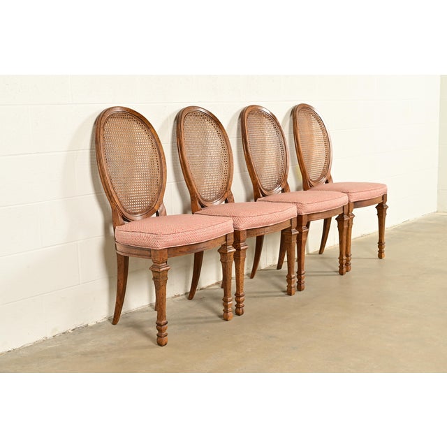 A gorgeous set of four French Regency Louis XVI style dining chairs By Drexel USA, Circa 1960s Carved walnut frames, with...