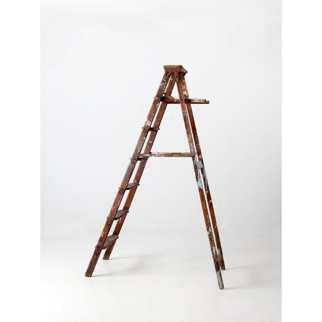 This tall vintage wooden painter’s ladder features six rungs and classic folding metal hinges. The weathered wood and...