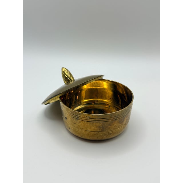 Vintage solid brass trinket box with a domed lid, engraved banding, and decorative finial. Made in India, this versatile...