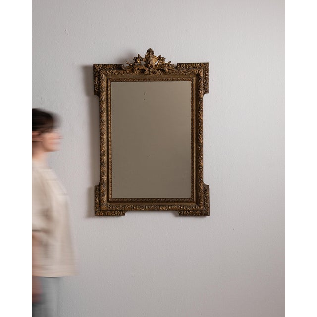 A mirror whose dark bronze ornate carved frame with crest gives it real character at first glance. It was made in France...