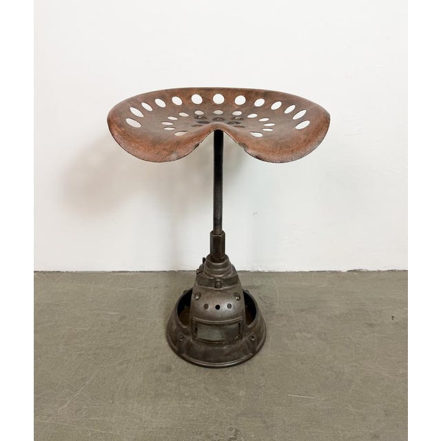 Vintage industrial height adjustable swivel chair from 1950s. An old tractor seat mounted on an iron construction....