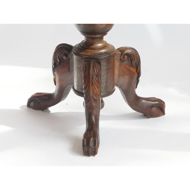 An antique carved round table made out of solid wood. The side table is standing on three wooden legs with beautiful...