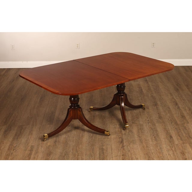 High Quality American Made Banded Rectangular Top Mahogany Dining Table on Carved Double Pedestal Base with Brass Capped...