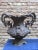 Pair of early 20th century cast iron urns with decorative foliate work and scroll handles. Beautiful shape and detail with...