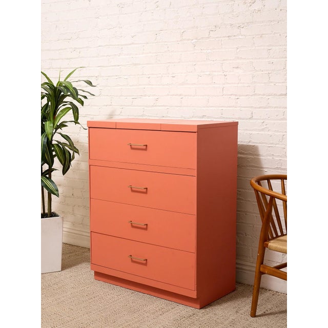 A bold vintage highboy dresser refinished in a saturated burnt orange, giving its clean, streamlined silhouette a fresh...