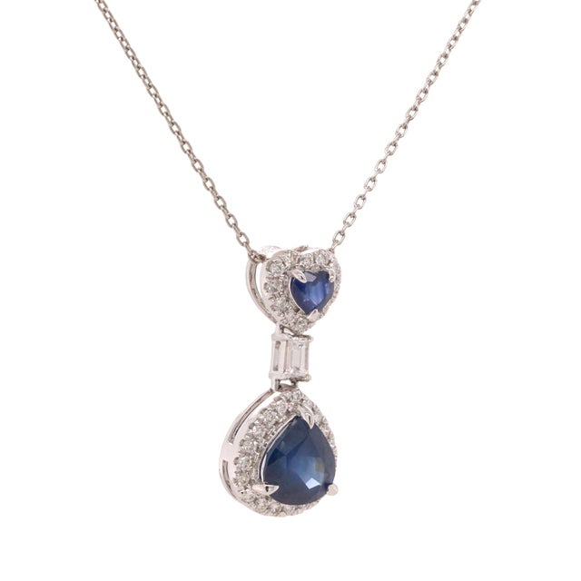 Elegant platinum necklace showcasing heart and pear sapphires surrounded by diamonds. A refined piece that blends romantic...
