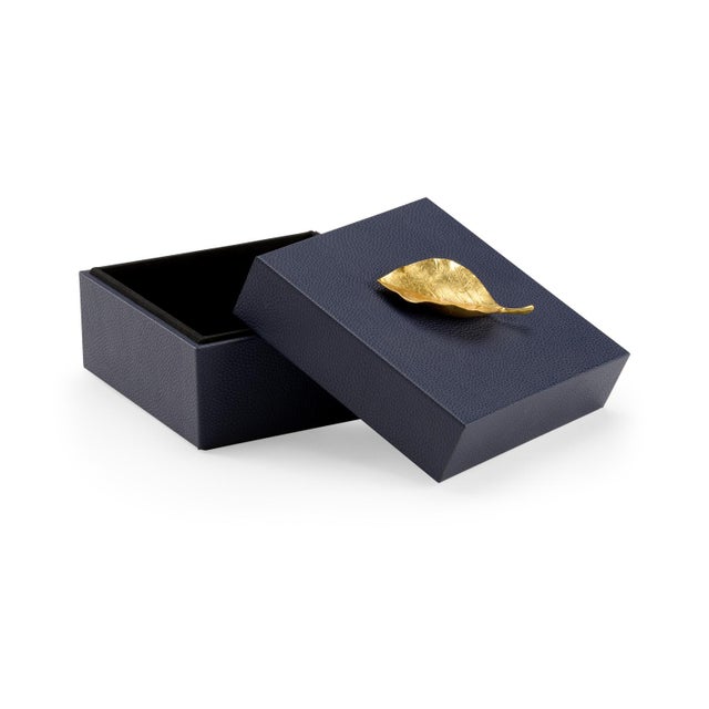 Felt Lined Wooden Box Covered In Navy Faux Leather With A Metallic Gold Leaf Handle. Clean with a dry cloth