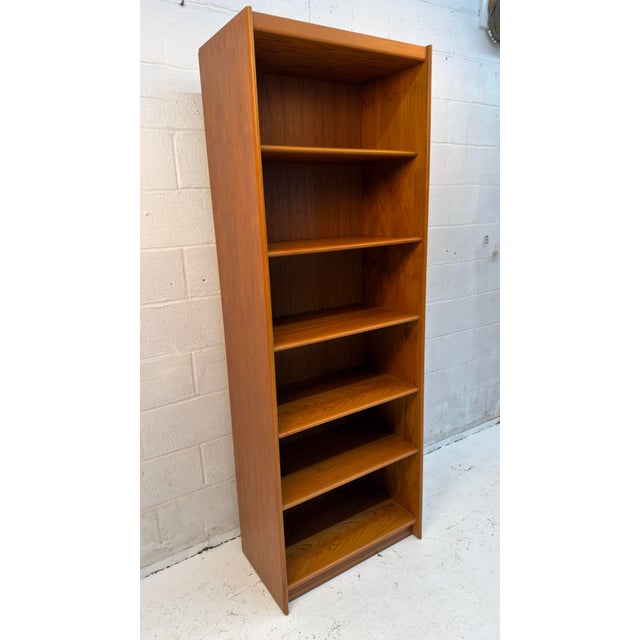 Classic Danish modern bookcase crafted in teak, featuring warm wood tones, beautiful natural grain, and clean, understated...