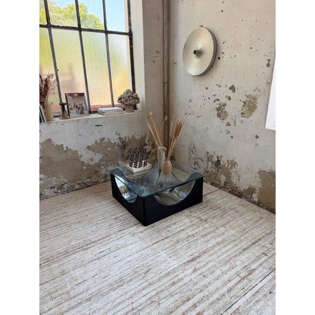 Vintage 1970s coffee table with a black patinated, molded base and graphic chrome details. We love its quintessential 70s...